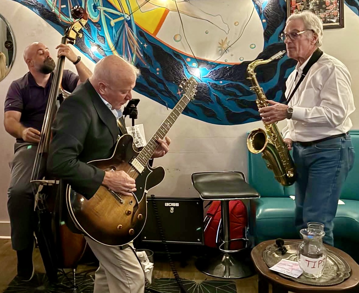 Jordan Tupper on upright bass, Jim Standley on guitar, and Glen Petersen on tenor saxophone performing live jazz in Baton Rouge